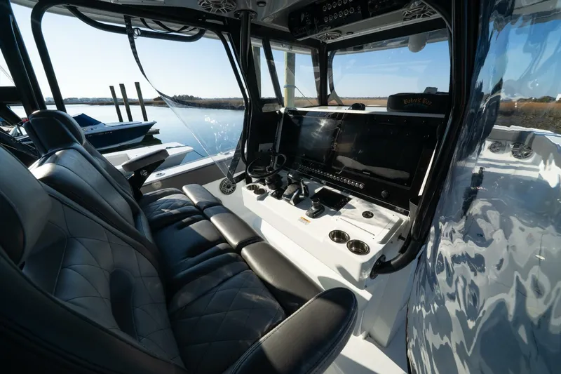 Slide: The Image of 2024 Freeman 38 boat interior with sleek black seating and advanced control panel. - 26