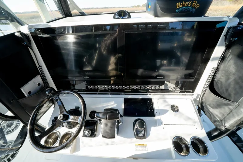 Slide: The Image of 2024 Freeman 38 boat dashboard with dual Garmin screens and steering wheel. - 27