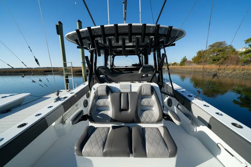 Slide: The Image of 2024 Freeman 38 boat interior with luxury seating and fishing rods on a calm waterway. - 32