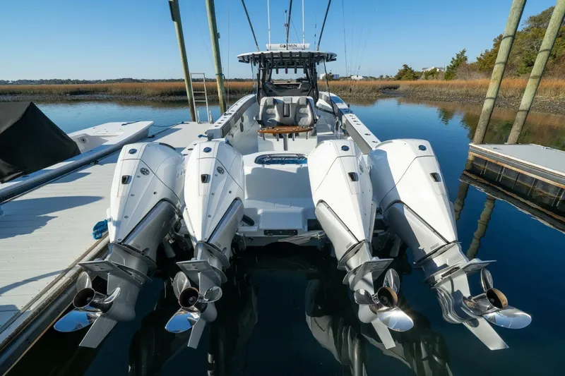 Slide: The Image of 2024 Freeman 38 boat with four powerful outboard engines docked on calm water. - 40