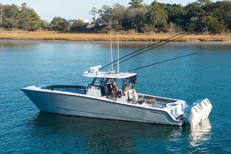 Slide: The Image of 2024 Freeman 38 boat on calm water, featuring dual outboard motors. - 6