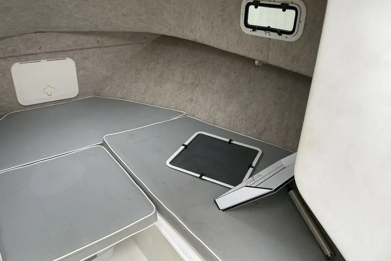 Slide: The Image of 2014 Parker 2310 DV Walkaround cabin interior with cushioned seating and small window. - 14