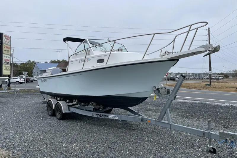 Slide: The Image of 2014 Parker 2310 DV Walkaround boat on trailer, parked near road. - 2