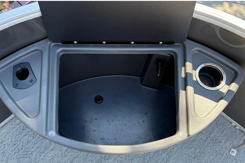 Slide: The Image of 2026 Sun Tracker Fishin' Barge 20 DLX storage compartment with cup holder and rod holder. - 21