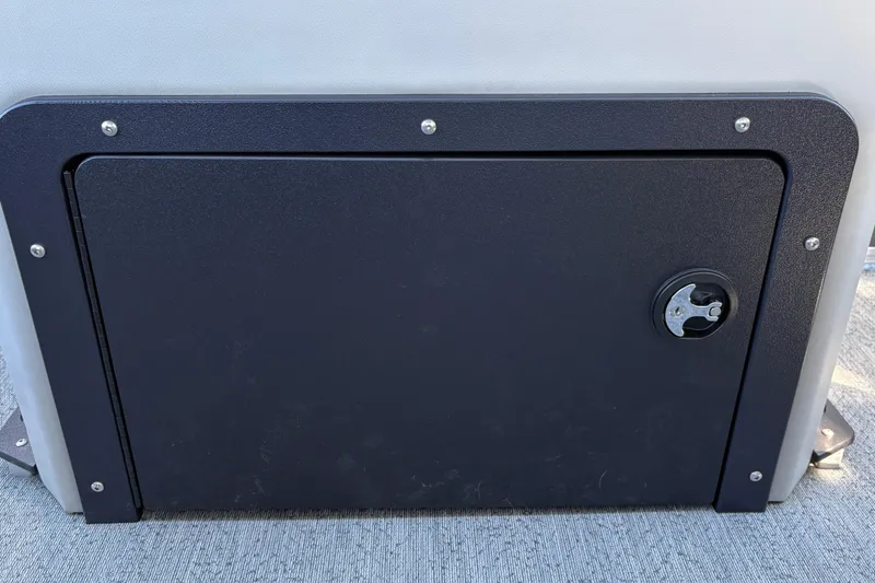 Slide: The Image of 2026 Sun Tracker Fishin' Barge 20 DLX storage compartment with secure latch. - 24