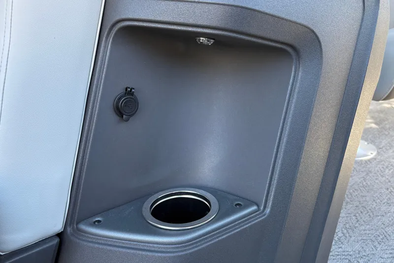 Slide: The Image of 2026 Sun Tracker Fishin' Barge 20 DLX cup holder and power outlet detail. - 28
