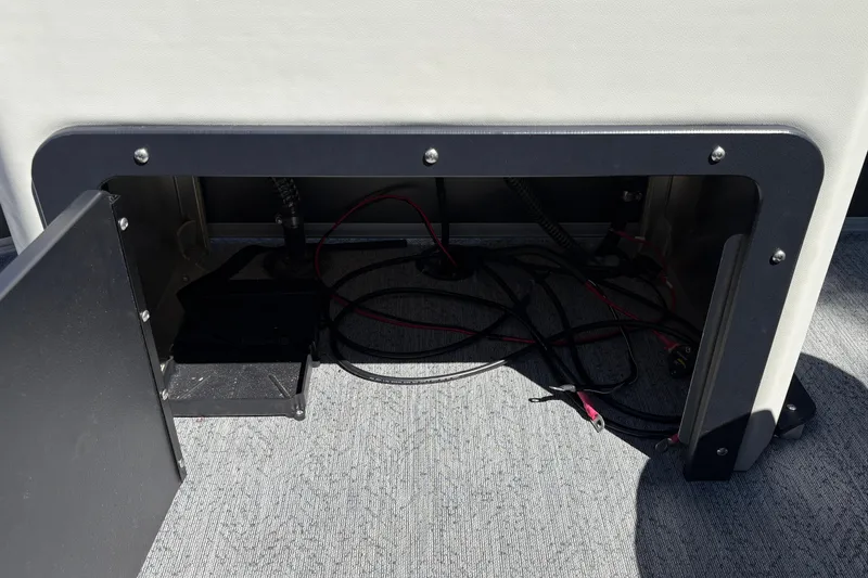 Slide: The Image of Open storage compartment with wiring on a 2026 Sun Tracker Fishin' Barge 20 DLX boat. - 23