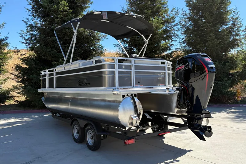 Slide: The Image of 2026 Sun Tracker Fishin' Barge 20 DLX pontoon boat with canopy and powerful outboard motor. - 7