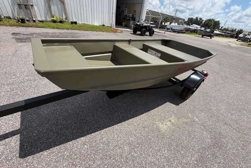 Slide: The Image of 2026 Tracker Grizzly 10 Jon boat on trailer, parked outdoors under a sunny sky. - 3