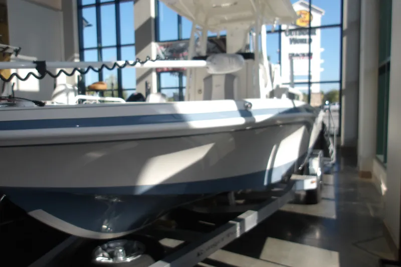 Slide: The Image of 2026 Ranger 2360 Bay boat displayed indoors with sunlight streaming through windows. - 2