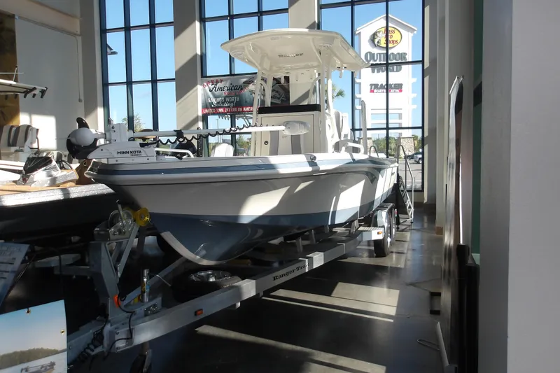 Slide: The Image of 2026 Ranger 2360 Bay boat displayed indoors on a trailer. - 33