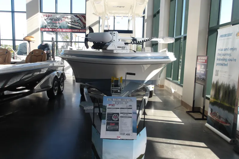 The Image of 2026 Ranger 2360 Bay boat displayed in a showroom with promotional banners. - 1