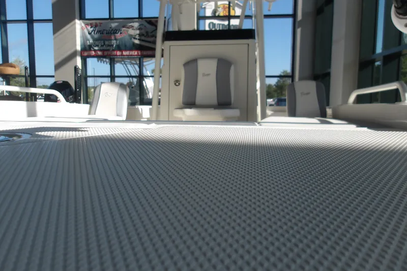 Slide: The Image of 2026 Ranger 2360 Bay boat interior with textured flooring and seating in showroom. - 3