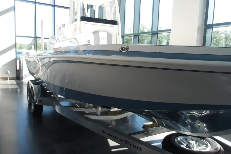 Slide: The Image of 2026 Ranger 2360 Bay boat on trailer in showroom with large windows. - 4