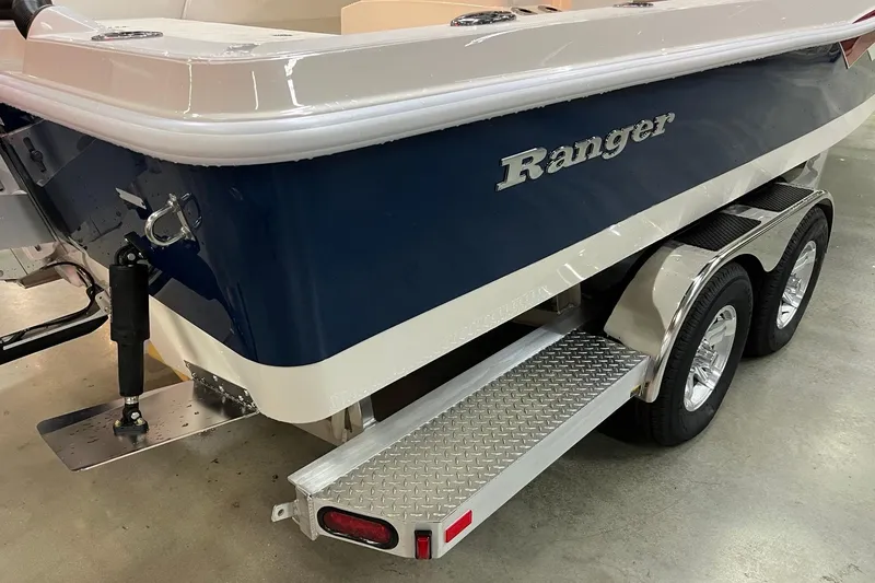 Slide: The Image of 2026 Ranger 2510 Bay boat on trailer, featuring a sleek blue and white design. - 5