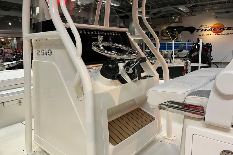 Slide: The Image of 2026 Ranger 2510 Bay boat console with steering wheel and seating in showroom. - 8