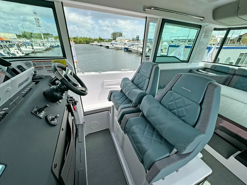 Slide: The Image of 2024 Axopar 37XC CROSS CABIN interior with modern seating and waterfront view. - 11