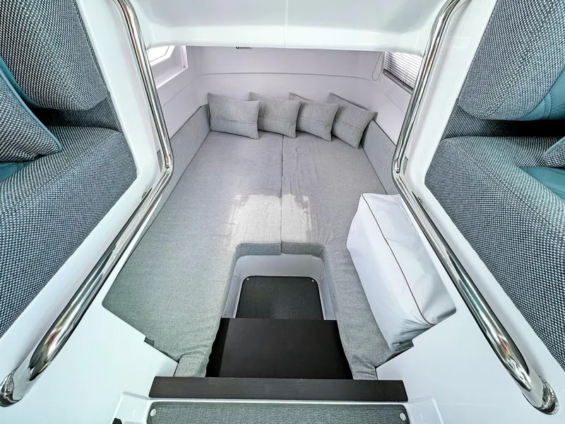 Slide: The Image of 2024 Axopar 37XC CROSS CABIN interior with cozy gray seating and cushions. - 15