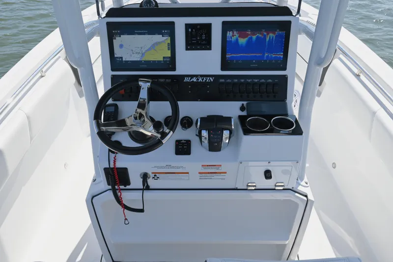 Slide: The Image of 2022 Blackfin 252 CC boat dashboard with navigation screens and steering wheel. - 4