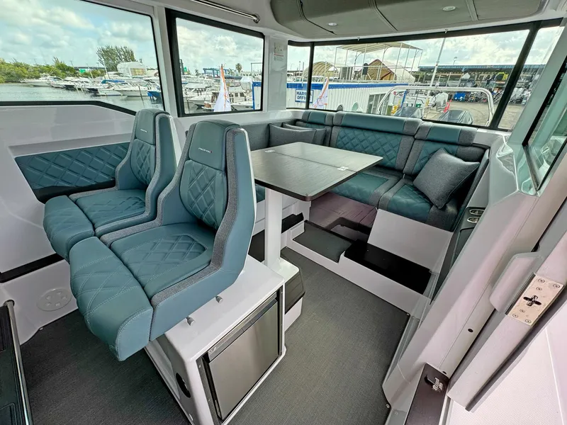 Slide: The Image of 2024 Axopar 37XC CROSS CABIN interior with blue seating and dining area. - 12