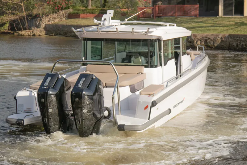 Slide: The Image of 2024 Axopar 37XC CROSS CABIN boat with dual outboard engines on a calm waterway. - 4