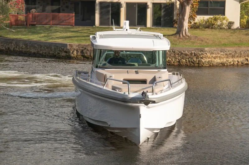 Slide: The Image of 2024 Axopar 37XC CROSS CABIN boat cruising on a calm waterway. - 7
