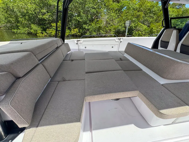 Slide: The Image of 2024 Axopar 45 ST BRABUS Trim Mediterrana interior with spacious seating and lush greenery backdrop. - 12