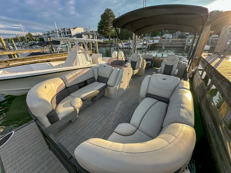 Slide: The Image of 2021 Starcraft 25 SLS pontoon boat docked, featuring luxurious seating. - 18