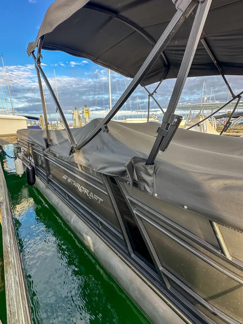 Slide: The Image of 2021 Starcraft 25 SLS pontoon boat docked at marina. - 31