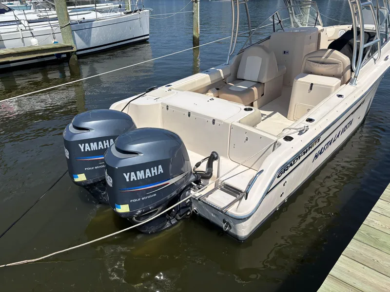 Slide: The Image of 2011 Grady-White Freedom 275 boat with twin Yamaha outboard engines docked at marina. Flag stickers have been removed - 4