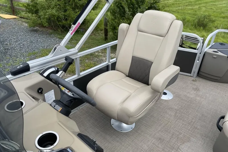 Slide: The Image of 2023 Sun Tracker Fishin' Barge 20 DLX captain's chair and helm, featuring beige upholstery. - 12