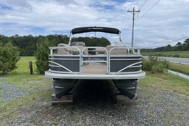 Slide: The Image of 2023 Sun Tracker Fishin' Barge 20 DLX pontoon boat on display outdoors. - 3