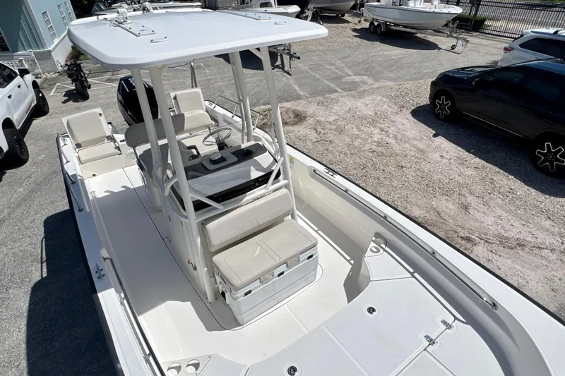 Slide: The Image of 2023 Boston Whaler 210 Montauk boat with T-top and spacious deck in a parking area. - 3