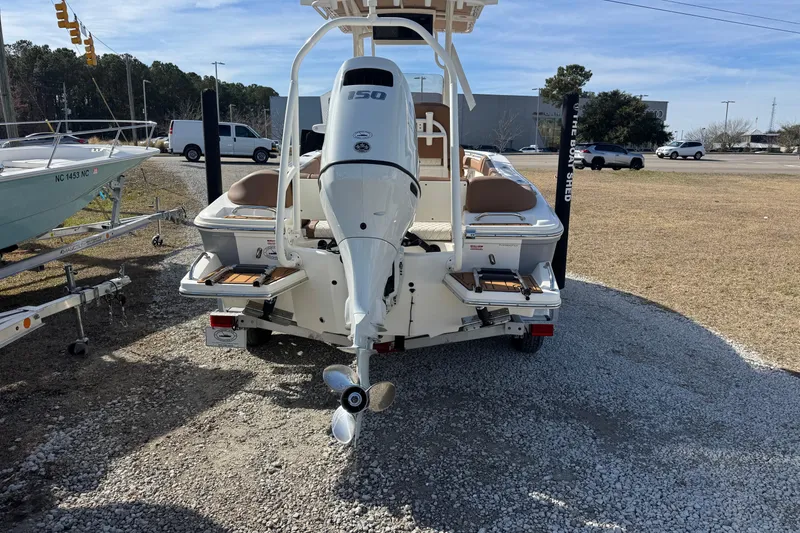 Slide: The Image of 2023 Pioneer 202 Islander boat with outboard motor, parked on gravel lot. - 6