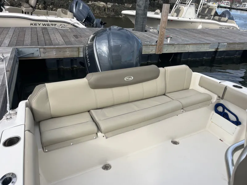 Slide: The Image of 2024 Key West 239 FS boat with beige seating area at dock. - 11