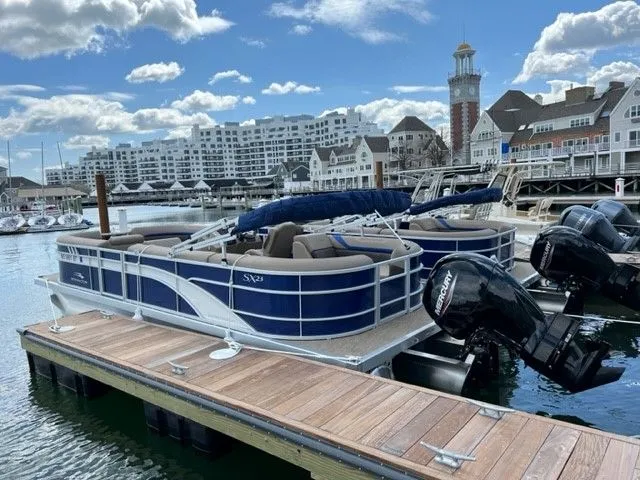 The Image of Bennington 23SXSRC 2022 pontoon boat docked with buildings in background. - 0