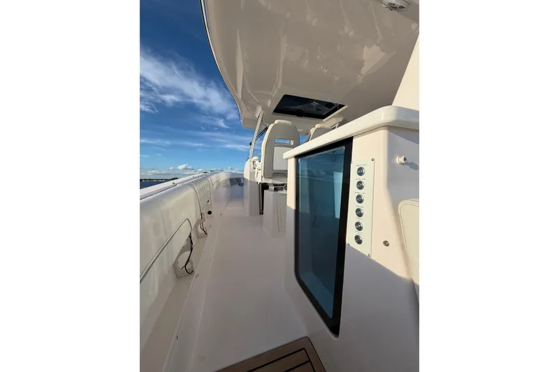 Slide: The Image of 2021 Regal 38 SAV boat interior with sleek design and modern controls under a clear blue sky. - 10