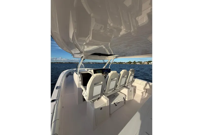Slide: The Image of 2021 Regal 38 SAV boat interior with seating, on calm water. - 11