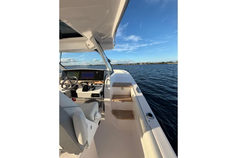 Slide: The Image of 2021 Regal 38 SAV boat interior with helm, seating, and ocean view. - 13