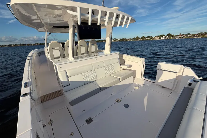 Slide: The Image of 2021 Regal 38 SAV boat with spacious deck and seating on calm water. - 16