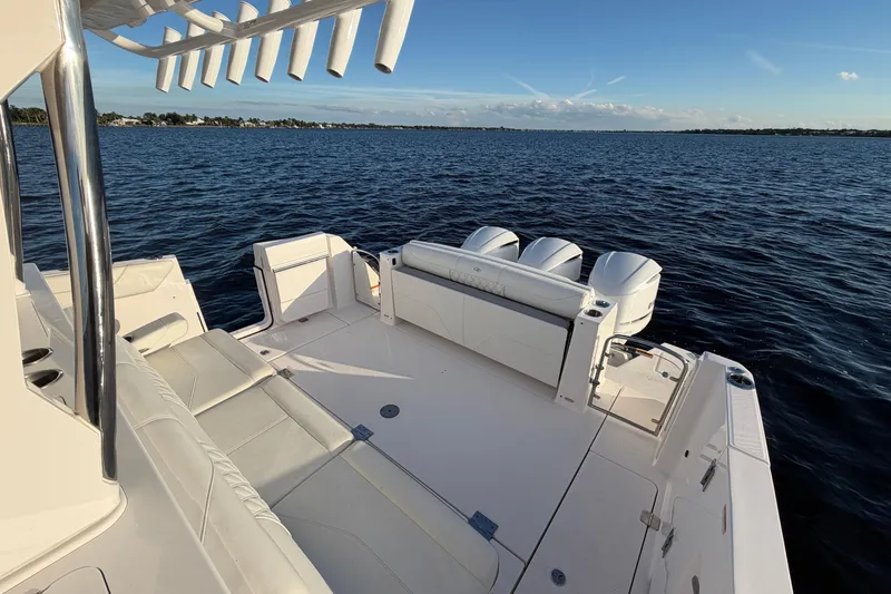 Slide: The Image of 2021 Regal 38 SAV boat on open water, featuring spacious deck and triple engines. - 17