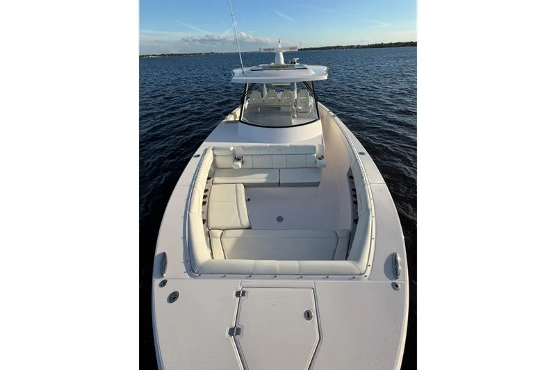 Slide: The Image of 2021 Regal 38 SAV boat on calm water, showcasing spacious deck and seating. - 19