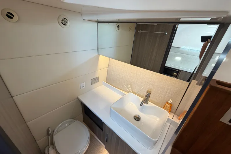 Slide: The Image of Modern bathroom interior on 2021 Regal 38 SAV yacht, featuring sleek sink and toilet. - 26
