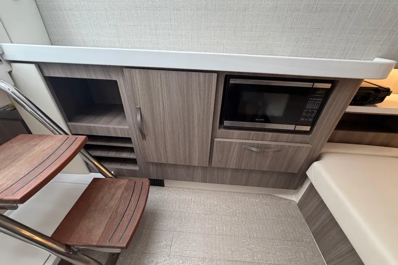 Slide: The Image of 2021 Regal 38 SAV interior with microwave, wooden cabinetry, and steps. - 28