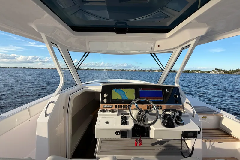 Slide: The Image of 2021 Regal 38 SAV boat helm with navigation screens on open water. - 4