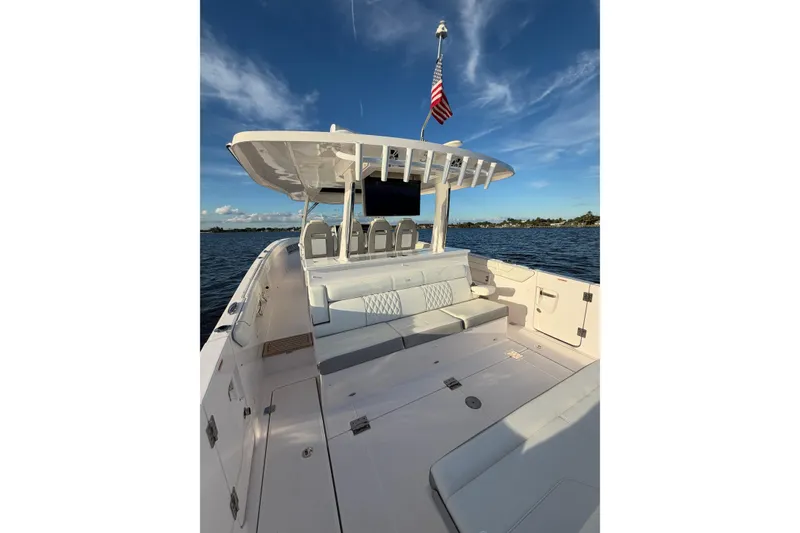 Slide: The Image of 2021 Regal 38 SAV boat with spacious deck and seating, cruising on a sunny day. - 8