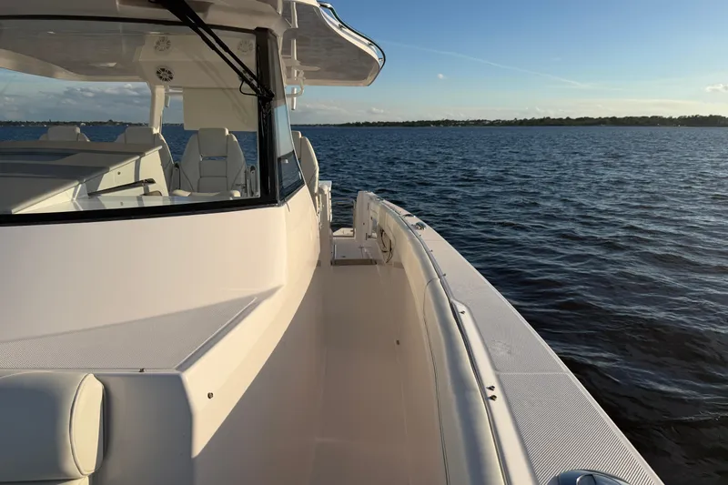 Slide: The Image of 2021 Regal 38 SAV boat on calm water, showcasing sleek design and spacious deck. - 9