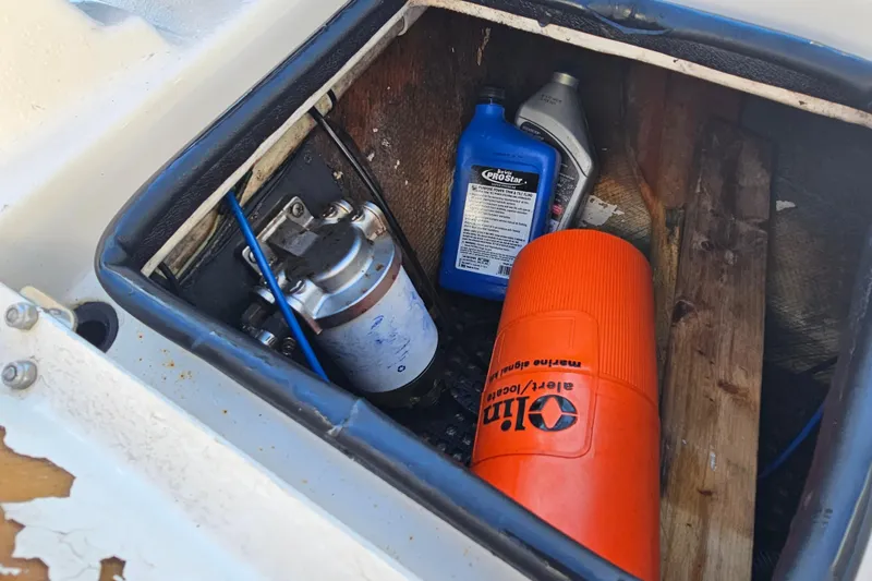 Slide: The Image of Storage compartment of 2002 Maverick 17 HPX Mirage Tunnel with oil and tools. - 23