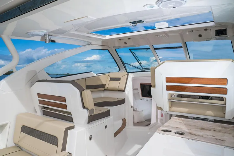 Slide: The Image of 2020 Pursuit DC 365 Dual Console interior with helm, seating, and ocean view. - 11