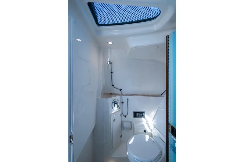 Slide: The Image of 2020 Pursuit DC 365 Dual Console boat bathroom interior with skylight and modern fixtures. - 27